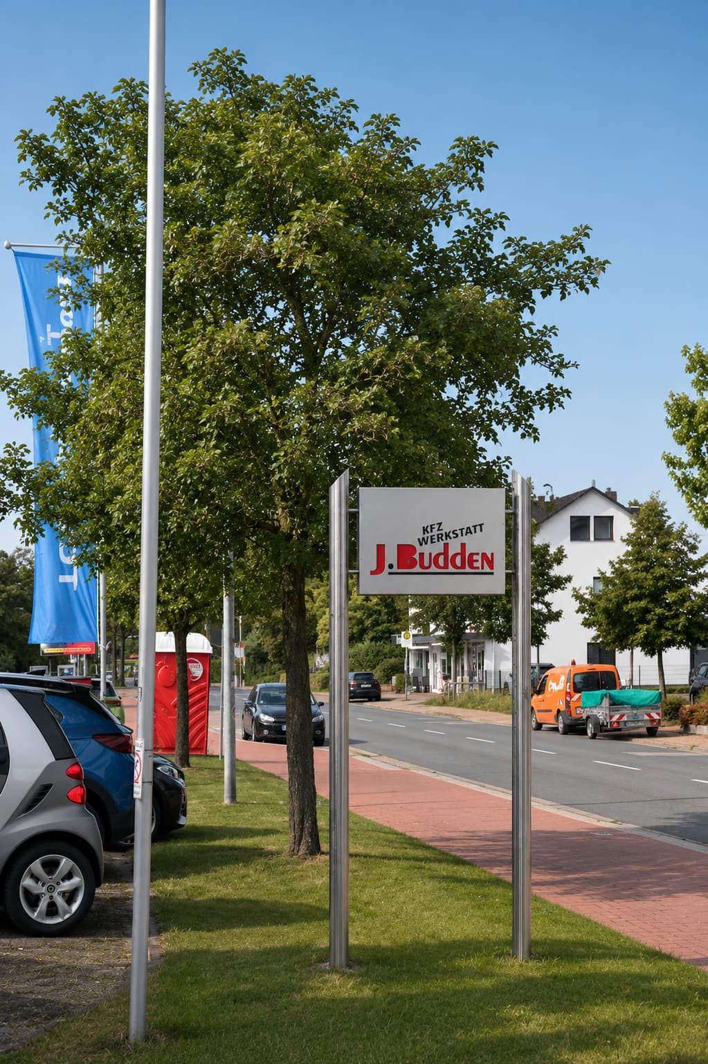 Einfahrt und Werkstattschild der Kfz-Werkstatt J. Budden in Rostrup
