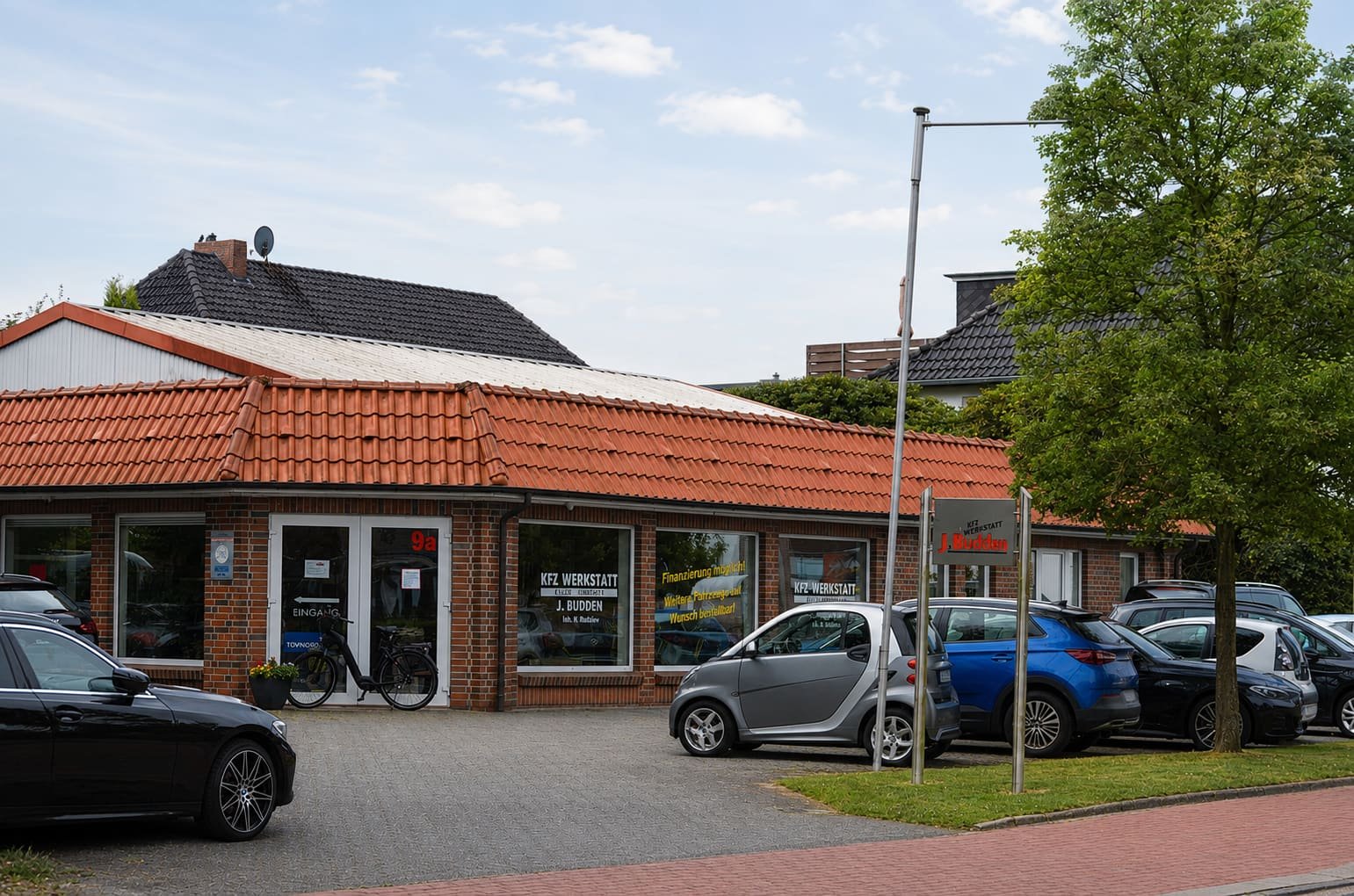 Kfz-Werkstatt J. Budden mit Fahrzeugen an der Elmendorfer Straße